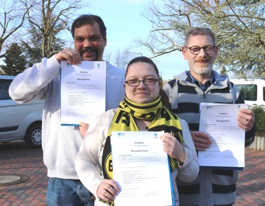 Drei Teilnehmer halten ihr Montagehelfer-Zertifika
