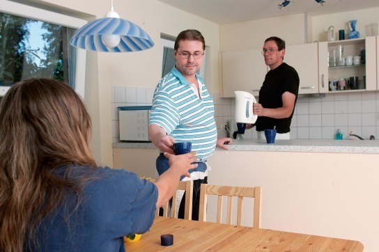 Hier sind 3 Personen in der Küche zu sehen in unserer Trainingswohnung Haus an der Au, Boostedt