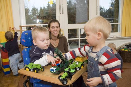 Zwei Jungs spielen mit Traktoren und Polizeiautos